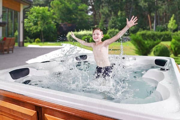 A happy boy jumping in the Arctic Spas Hot Tub